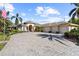 Beautiful single-story home featuring a three-car garage, brick paved driveway, and tropical landscaping at 793 Vanderbilt Dr, Nokomis, FL 34275