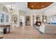 Spacious living room featuring a wood tray ceiling, neutral decor, arched doorways, and tile floors at 793 Vanderbilt Dr, Nokomis, FL 34275