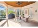 Covered patio with outdoor seating, ceiling fan, and a serene view of the lush landscaping at 793 Vanderbilt Dr, Nokomis, FL 34275