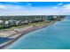 An aerial view of a Florida beach with turquoise water and residential buildings on a clear, sunny day at 842 Nokomis S Ave, Venice, FL 34285
