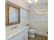 Charming powder room with decorative wallpaper, white wainscoting, and a framed mirror at 842 Nokomis S Ave, Venice, FL 34285