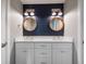 Bathroom with double vanity, blue shiplap, and round mirrors at 842 Nokomis S Ave, Venice, FL 34285
