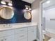 Stylish bathroom featuring a double vanity, navy accent wall, and a glass-enclosed shower at 842 Nokomis S Ave, Venice, FL 34285