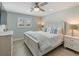 Bright bedroom featuring light walls, wood-look flooring, a ceiling fan and a large white cottage style bed with blue accents at 842 Nokomis S Ave, Venice, FL 34285