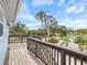 Wooden deck with stairs and railing overlooking a neighborhood with palm trees on a clear day at 842 Nokomis S Ave, Venice, FL 34285