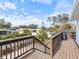 Wooden deck and railing with steps and trees and residential homes in the background on a clear day at 842 Nokomis S Ave, Venice, FL 34285