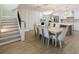 Open-concept dining room features a modern chandelier, wood floors, and seamless flow into the kitchen at 842 Nokomis S Ave, Venice, FL 34285