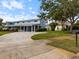 Two-story exterior showcasing charming blue siding, manicured lawn, and paved driveway at 842 Nokomis S Ave, Venice, FL 34285