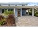 Inviting entrance with modern wood door, paver walkway, and convenient covered parking at 842 Nokomis S Ave, Venice, FL 34285