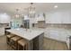 Bright kitchen boasts white cabinetry, a large island with seating, and stainless steel appliances at 842 Nokomis S Ave, Venice, FL 34285