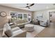 Bright living room with neutral tones, wood floors, ceiling fan, and multiple seating areas at 842 Nokomis S Ave, Venice, FL 34285
