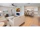 Open-concept living area featuring modern fireplace, wood floors, and seamless dining and kitchen at 842 Nokomis S Ave, Venice, FL 34285