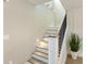 Modern staircase with white risers and dark wood treads, accented by lighting at 842 Nokomis S Ave, Venice, FL 34285