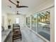 Sunroom with pool access, wicker furniture and ceiling fans at 842 Nokomis S Ave, Venice, FL 34285
