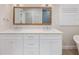 Bathroom vanity with double sinks, white cabinets, and decorative mirror at 842 Nokomis S Ave, Venice, FL 34285