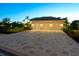 Three-car garage with paver driveway, well-lit at night at 11 Carisa Royale Ct, Englewood, FL 34223