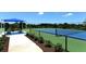 Tennis court with blue surface and shaded seating at 12664 Sagewood Dr, Venice, FL 34293