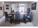 Bright dining room with a wooden table and four blue chairs, overlooking the kitchen at 145 Jose Gaspar Dr # 145, Englewood, FL 34223