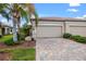 Tan house with three-car garage and paver driveway at 19874 Benissimo Dr, Venice, FL 34293