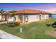 Single-Gathering home exterior with lake view and lush landscaping at sunset at 24176 Spartina Dr, Venice, FL 34293