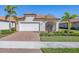 Single-Gathering home exterior featuring a white garage door and landscaping at 24176 Spartina Dr, Venice, FL 34293