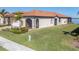 Single-Gathering home exterior with lake view and lush landscaping at 24176 Spartina Dr, Venice, FL 34293