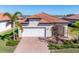 Single-Gathering home exterior with white garage door and brick driveway at 24176 Spartina Dr, Venice, FL 34293