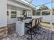 Outdoor kitchen with stainless steel appliances and bar seating at 2480 Soprano Ln, North Port, FL 34286