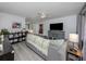 Living room with gray sofa, built-in shelving, and large TV at 3181 Nekoosa St, North Port, FL 34287