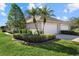 Side view of a villa showcasing its beige exterior, two-car garage, and well-maintained landscaping at 3897 Fairway Dr, North Port, FL 34287