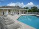 Community pool and clubhouse with seating areas at 3897 Fairway Dr, North Port, FL 34287