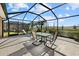 Large screened patio with table, chairs, and lounge chair at 3897 Fairway Dr, North Port, FL 34287