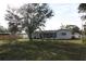 Spacious backyard with large tree, grassy area, and privacy fence at 4137 Maceachen Blvd, Sarasota, FL 34233