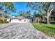 White two-car garage condo with paver driveway and mature landscaping at 4765 Oak Forest W Dr # 47, Sarasota, FL 34231