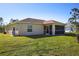 Tan house exterior with screened patio and lush lawn at 5268 Delight Ave, North Port, FL 34288