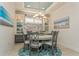 Bright dining room with round table, gray chairs, and a beautiful chandelier at 5837 Semolino St, Nokomis, FL 34275