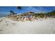 Beachfront view with people enjoying the sand and a nearby restaurant at 6405 Gulf Dr, Holmes Beach, FL 34217