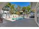 Inviting pool area surrounded by lush palm trees and a white privacy fence at 6405 Gulf Dr, Holmes Beach, FL 34217