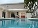 Relaxing backyard pool with a sitting area, palms, and white privacy fence at 6405 Gulf Dr, Holmes Beach, FL 34217
