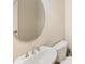 Close-up of a powder room with a round mirror, pedestal sink, and a white toilet at 660 Ravello Blvd, Nokomis, FL 34275