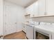 Laundry room with white cabinets, sink, and a modern washer and dryer at 660 Ravello Blvd, Nokomis, FL 34275
