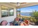 Screened patio featuring a ceiling fan, wicker furniture, and a serene waterfront view at 660 Ravello Blvd, Nokomis, FL 34275