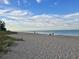 Peaceful beach view with calm ocean and people relaxing at 9028 Coachman Dr, Venice, FL 34293