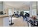 View of living area from kitchen with piano, bar seating, and entryway access at 143 Fontanelle Cir, Venice, FL 34292