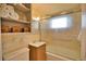 Clean bathroom with shower/tub combo, built-in shelves, and updated vanity at 1605 Phillip Pl, Englewood, FL 34223