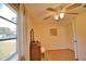 Well-lit bedroom with ceiling fan, antique vanity, and wood floors at 1605 Phillip Pl, Englewood, FL 34223