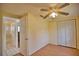 Simple bedroom with ceiling fan, wood flooring, and adjacent bathroom at 1605 Phillip Pl, Englewood, FL 34223