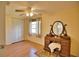 Charming bedroom with ceiling fan, antique vanity, and wood flooring at 1605 Phillip Pl, Englewood, FL 34223