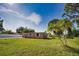 Cute Florida home with a spacious lawn, palm trees, and a fenced yard at 1605 Phillip Pl, Englewood, FL 34223