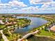 Aerial view of community with lake, bridge, and lush landscaping at 19303 Jacinda St, Venice, FL 34293